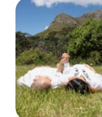Matric ball couple lying together on the grass, Cape Town mountain backdrop