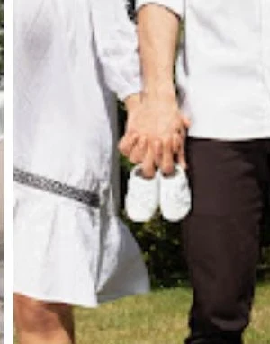 Couple holding a pair of tiny baby shoes